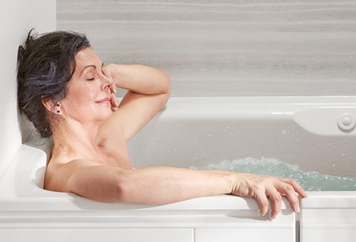 Woman relaxing in KOHLER Walk-In Bath