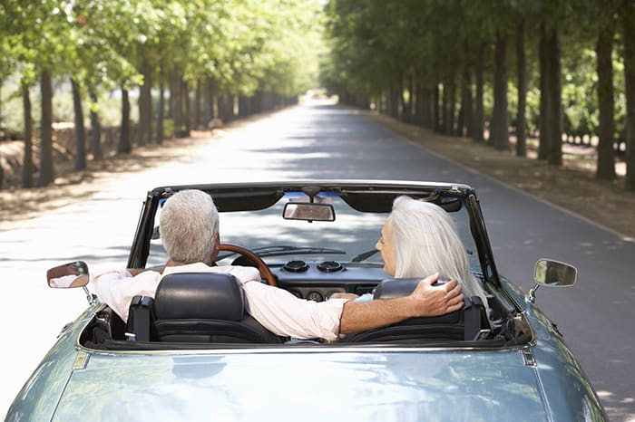 Old man and woman driving in car